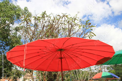 Red umbrella in the market.The sky and trees are the background.