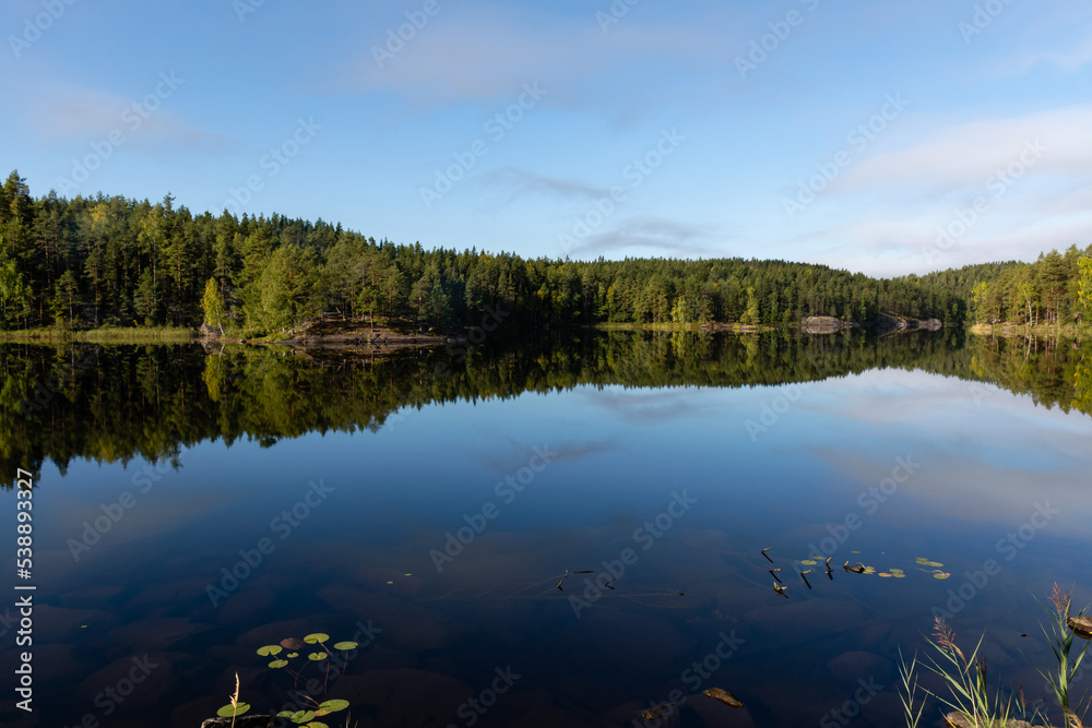 Beautiful Finnish lake view with the reflection from calm water in autumn.