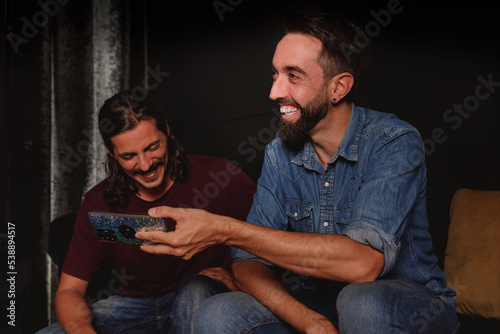 young friends using mobile smartphone indoor - millennial generation having fun with new trends social media apps