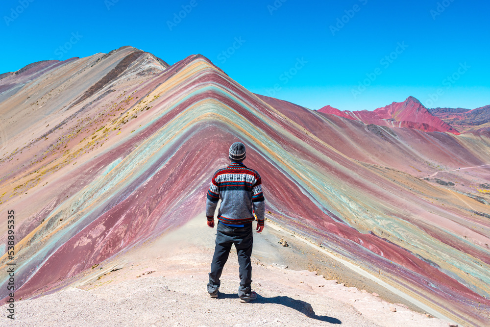 a man is looking vinicunca rainbow mountains, peru