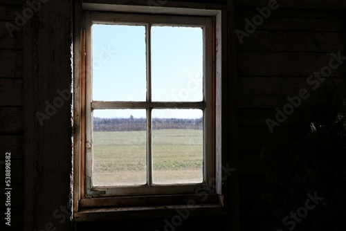 Vielle fenêtre dans une grange donnant sur un champ pendant l'hiver