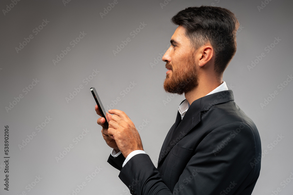 Young businessman using mobile phone in studio Young businessman using mobile phone in studio