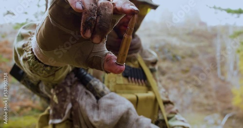 Soldier showing a cartridge to the camera. Cartridge close-up in the hand of a soldier. photo