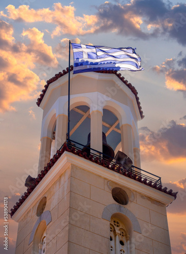 Greek flag on the bell tower of the Church of St. John the Russian in Greece photo