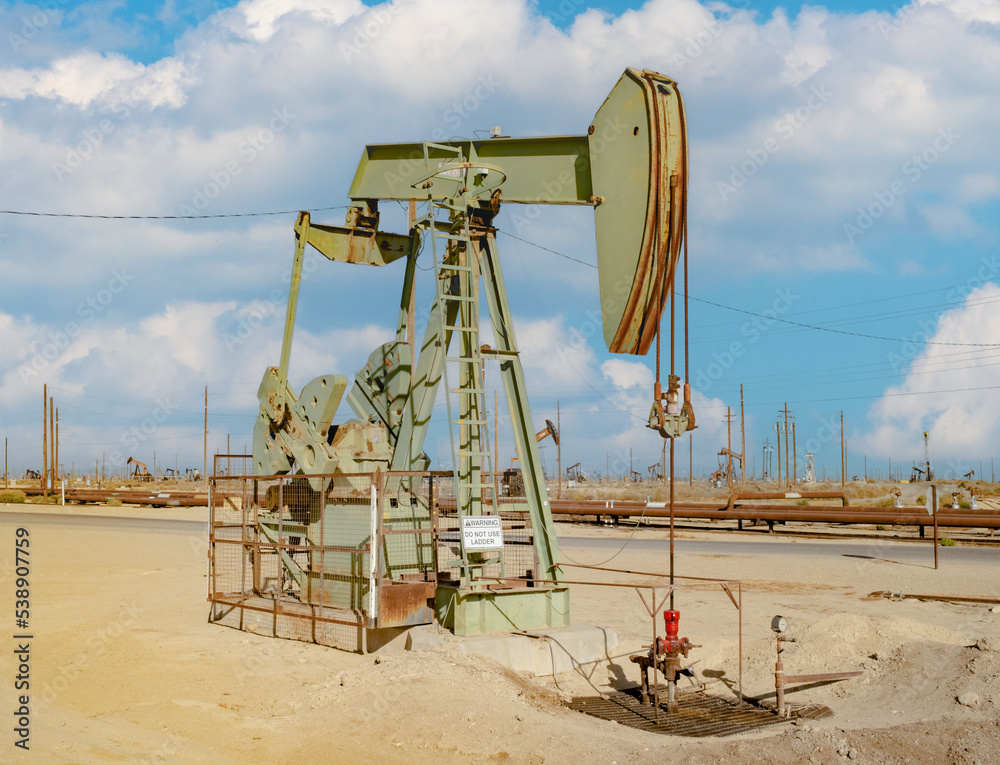 Multiple oil pumps in a desert oil field pumping crude oil into an