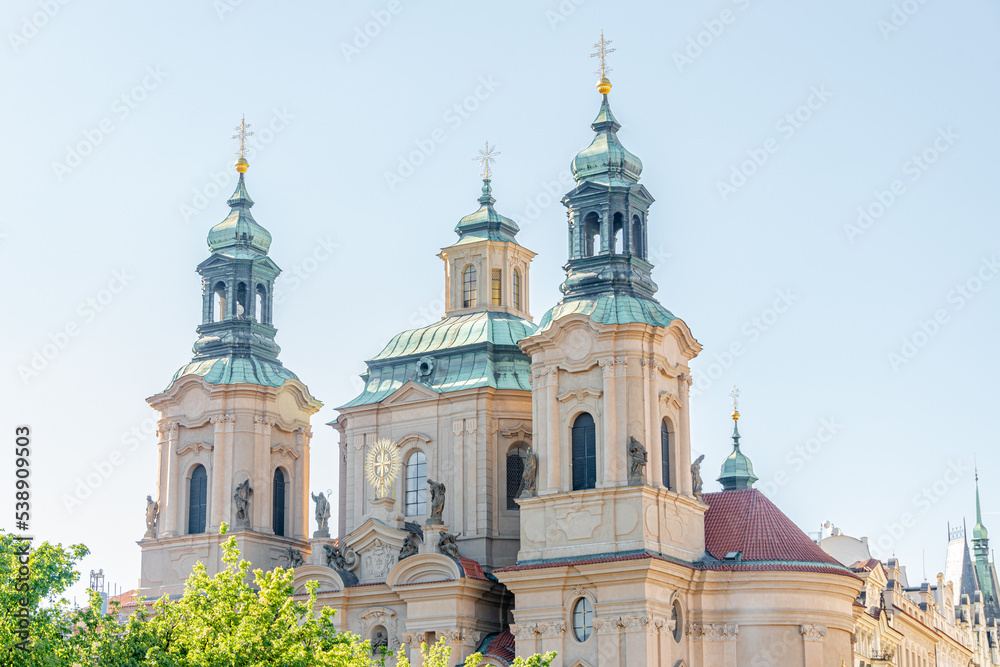 Saint Nicholas Church with bell towers near the castle and Saint Vitus Cathedral in Prague historical downtown, Czech Republic, at blue sky and sunny day.