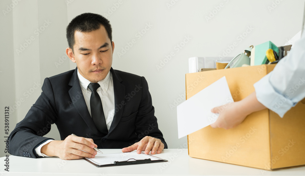 Desperately fired female office worker employee hands her employer her resignation letter and packs her belongings in a cardboard box concept dismissal and unemployment Desperately fired female office worker employee hands her employer her resignation letter and packs her belongings in a cardboard box concept dismissal and unemployment