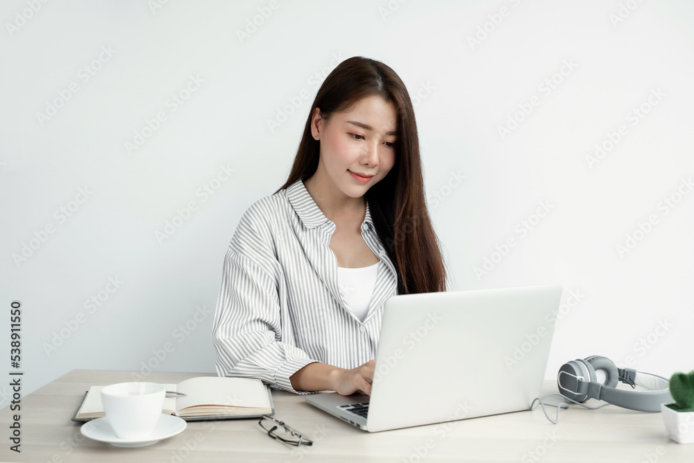 Asian businesswoman working on laptop computer About happy business projects sitting at your desk at home Asian businesswoman working on laptop computer About happy business projects sitting at your desk at home