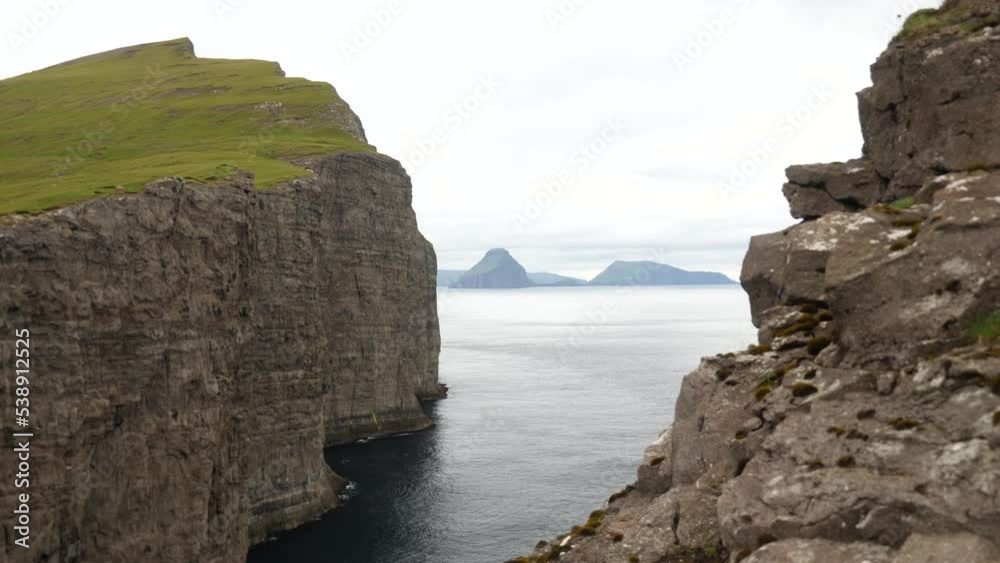 A gap in the rock. A huge mountain or a rock formation next to a Sorvagsvatn lake or Leitisvatn, Biggest lake in Faroe Islands. High quality 4k footage. Amazing nature. Lake above the ocean. A gap in the rock. A huge mountain or a rock formation next to a Sorvagsvatn lake or Leitisvatn, Biggest lake in Faroe Islands. High quality 4k footage. Amazing nature. Lake above the ocean.