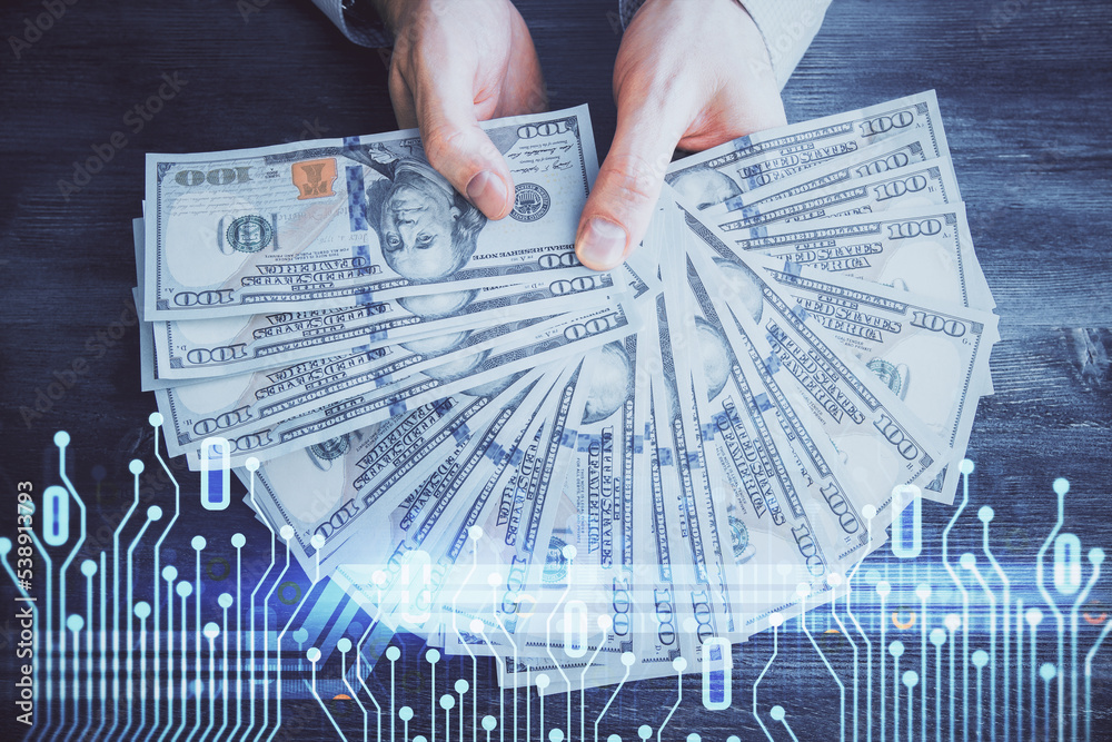 Multi exposure of technology drawing hologram and us dollars bills and man hands. Data concept Multi exposure of technology drawing hologram and us dollars bills and man hands. Data concept
