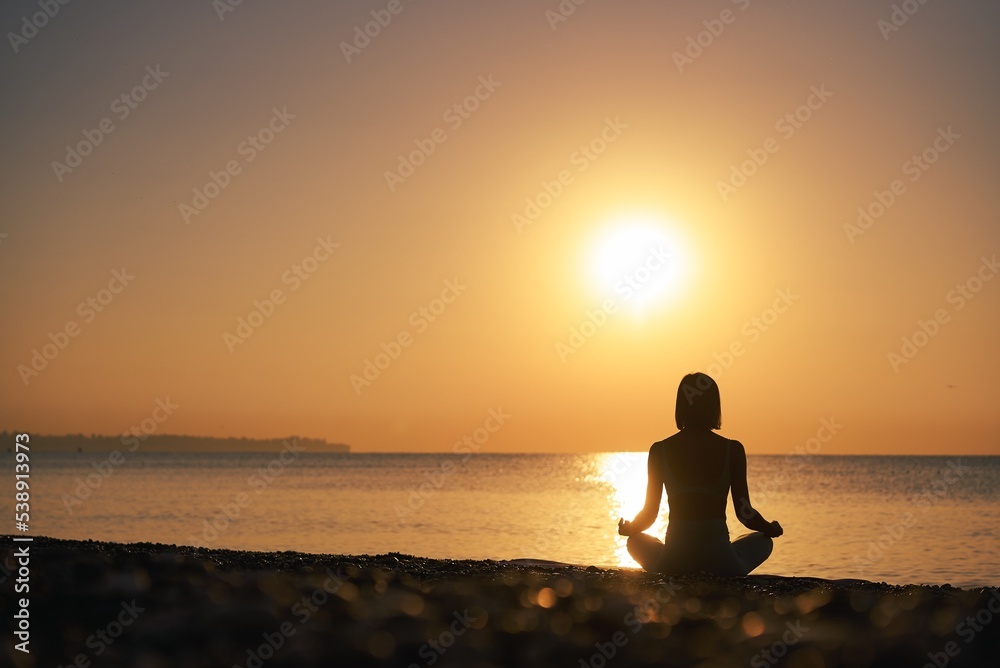 Silhouette young woman practicing yoga on the beach at sunset, Karon Beach ,Phuket ,Thailand. For background and texture. High quality photo