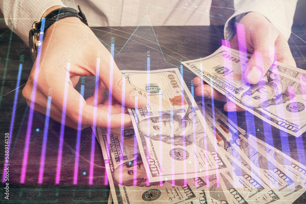 Multi exposure of financial graph drawing hologram and USA dollars bills and man hands. Analysis concept. Multi exposure of financial graph drawing hologram and USA dollars bills and man hands. Analysis concept.