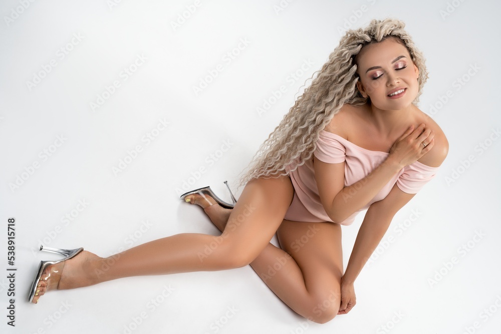 Naklejka premium Sensual woman in underwear sitting in studio