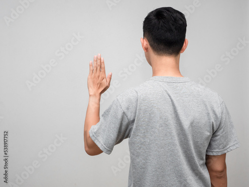 Behind of man grey shirt standing show hand to stop isolated