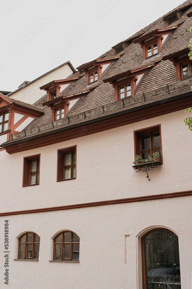 Old historic architecture in Nuremberg, Germany. Traditional European old town building with wooden windows, shutters and colourful pastel walls. Aesthetic summer vacation, tourism background