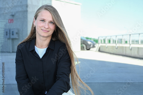 Close up portrait of smilling 35 years old woman with long natural hair. Flying blonde hair on the wind. Vertical photo