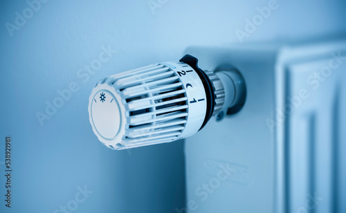 White panel radiator with a modern thermostat on the wall in an apartment - selective focus