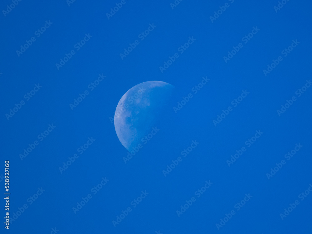 a close-up photo of the moon against a blue sky