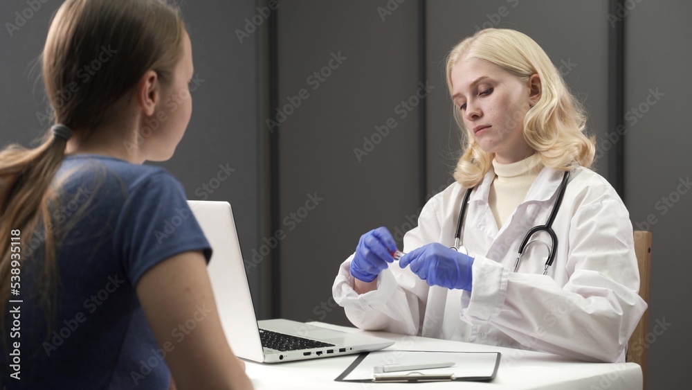 Fototapeta premium Doctor's hand in blue protective medical gloves taking pernasal swab for covid to adult in mobile lab