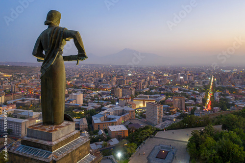 View of Mother Armenia Statue, Eternal Fire in Akhtanak Park and the city in the evening. Yerevan, Armenia. photo