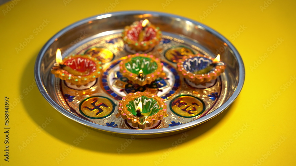 Oil lamps lit on colorful rangoli during diwali celebration. Happy Diwali - Clay Diya lamps lit during Diwali, Hindu festival of lights celebration. Colorful traditional oil lamp diya