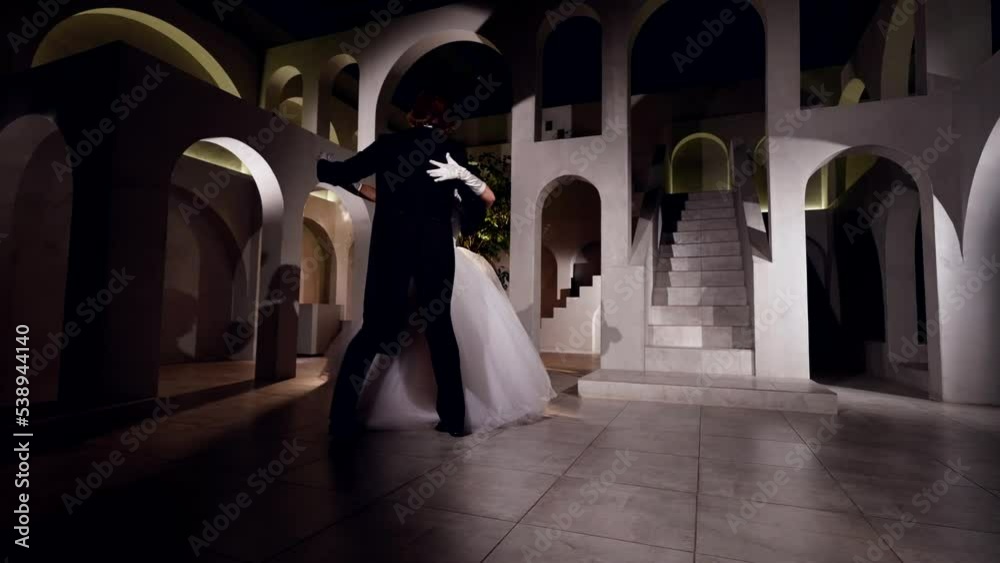 young brunette woman and handsome man are dancing waltz gracefully in dark ballroom young brunette woman and handsome man are dancing waltz gracefully in dark ballroom