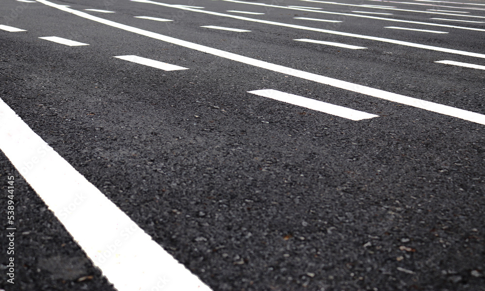 White multiple lines on dark grey asphalt road. White multiple lines on dark grey asphalt road.