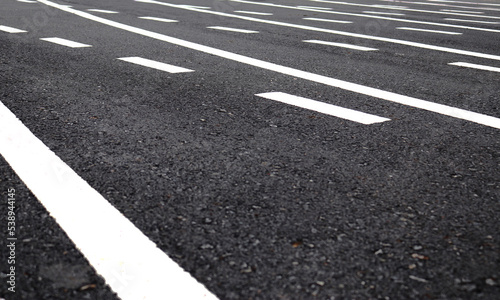 White multiple lines on dark grey asphalt road.
