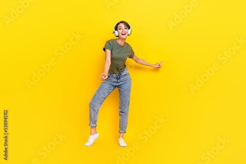 Full length photo of positive cool lady stylish clothes good mood finger hand point show empty space isolated on yellow color background