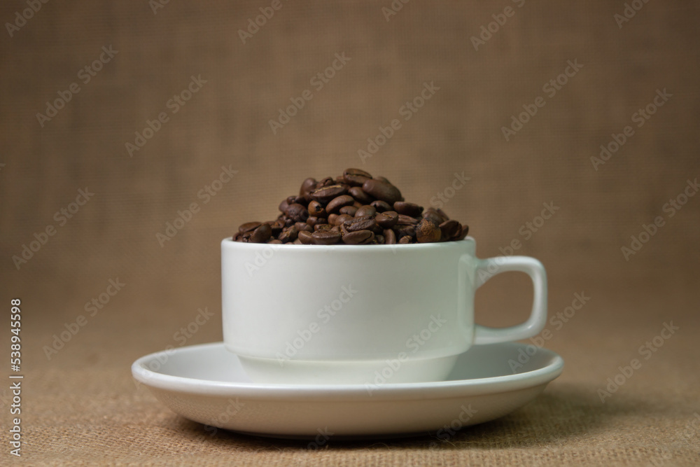 White cup full of coffee beans. natural coffee drink White cup full of coffee beans. natural coffee drink