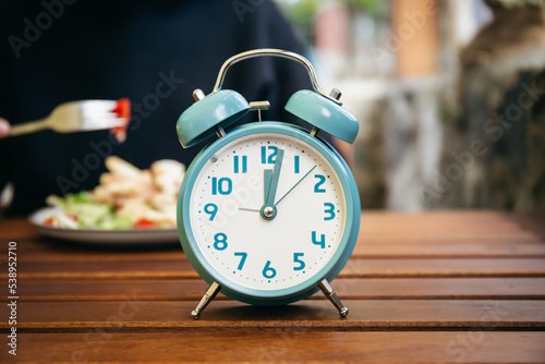 Close-up, alarm clock on a blurred food background. photo