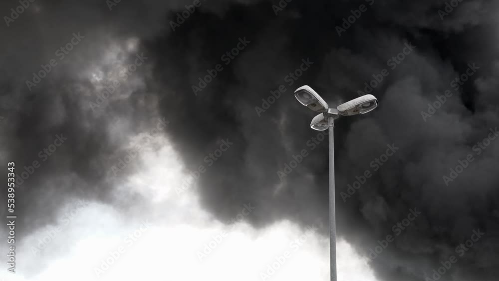 Street lamp with dark smoke in the background.
