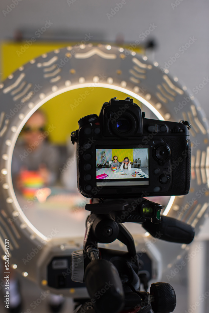 selective focus of video camera in circle lamp with preteen bloggers in trendy sunglasses on screen selective focus of video camera in circle lamp with preteen bloggers in trendy sunglasses on screen