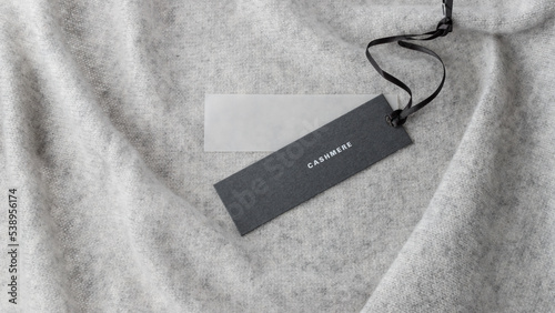 Dark paper tag with word cashmere on light grey luxury pure cashmere  background. photo