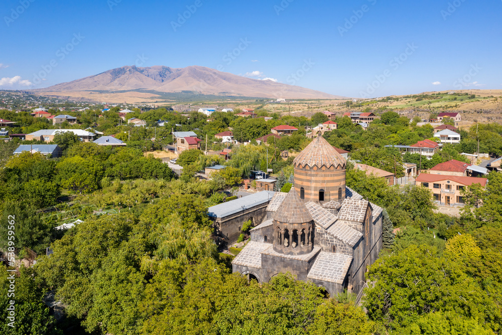 Drone view of Surp Gevorg Church (1661-1669) and Mount Ara on sunny summer day. Mughni village, Armenia.