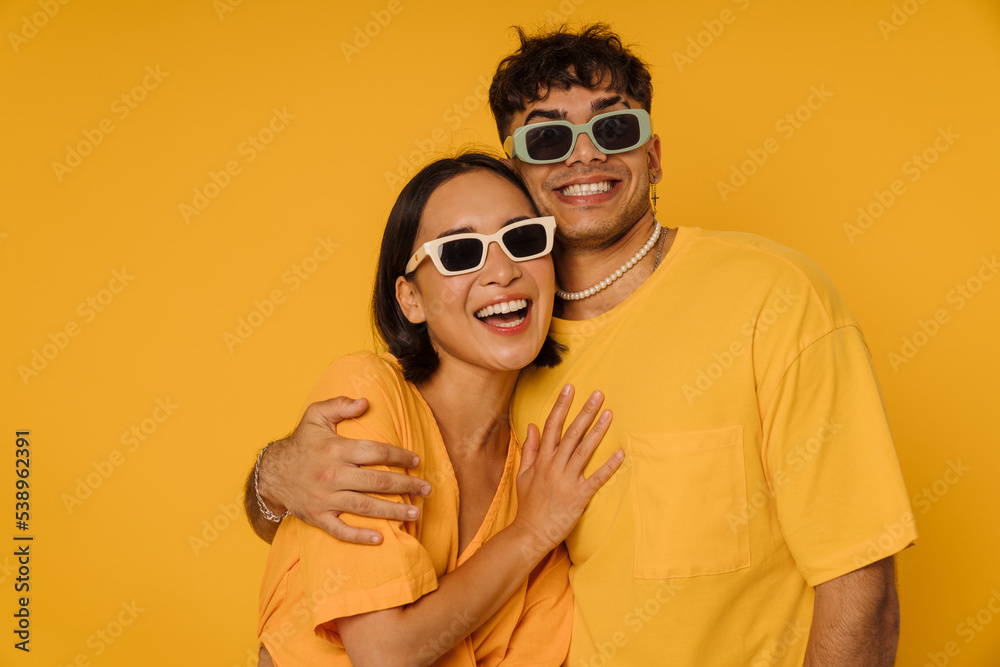 Young stylish smiling man hugging his happy girlfriend