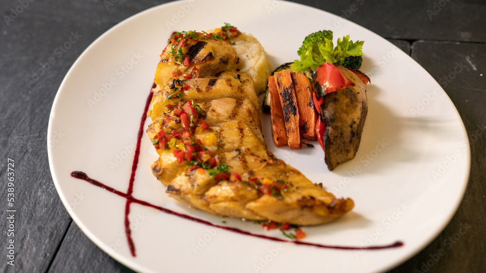 grilled fish with grilled vegetables and sause. black background