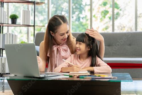 Wallpaper Mural Asian family portrait, father and daughter in the living room The daughter did her homework with her mother, giving advice and teaching closely. Torontodigital.ca