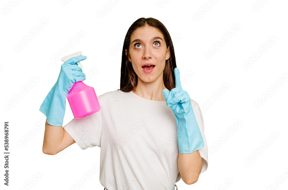 Young cleaner woman isolated pointing upside with opened mouth. Young cleaner woman isolated pointing upside with opened mouth.