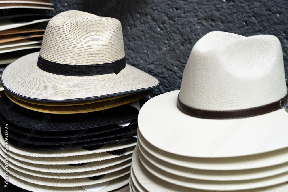 Panama hats piled up on street store. Men colorful accessories stack, souvenir concepts