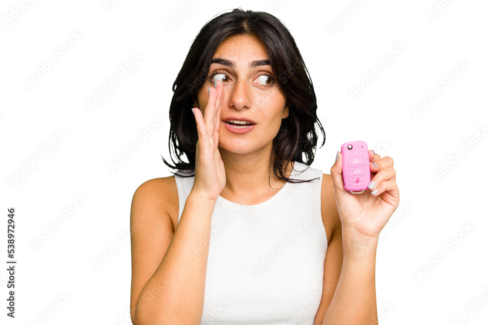 Young Indian woman holding a car keys isolated is saying a secret hot braking news and looking aside Young Indian woman holding a car keys isolated is saying a secret hot braking news and looking aside