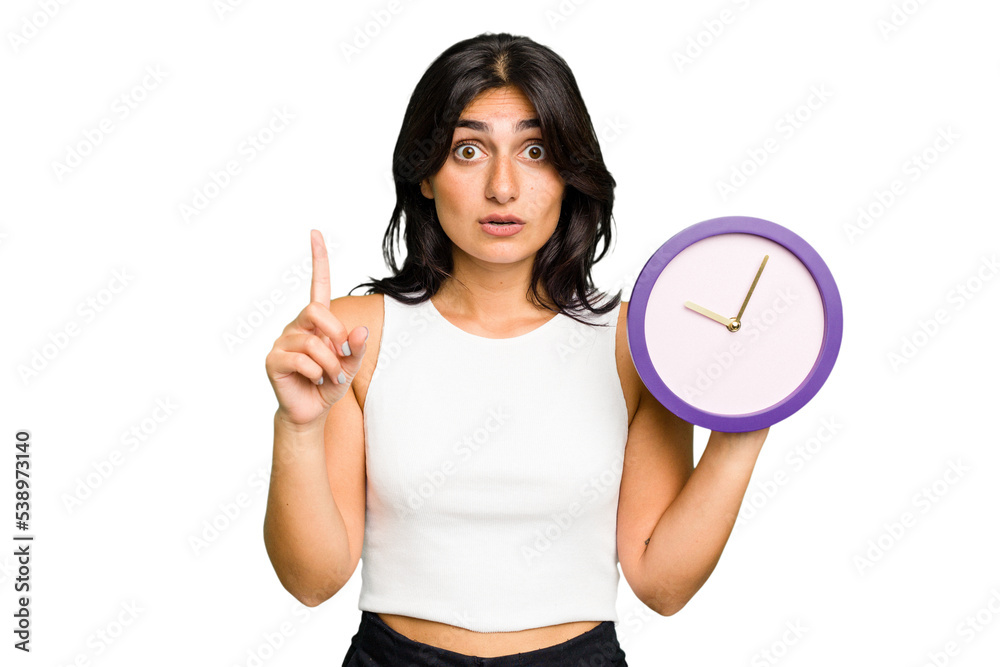 Young Indian woman holding a clock isolated having some great idea, concept of creativity. Young Indian woman holding a clock isolated having some great idea, concept of creativity.