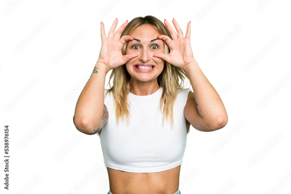 Young caucasian woman isolated on green chroma background keeping eyes opened to find a success opportunity.