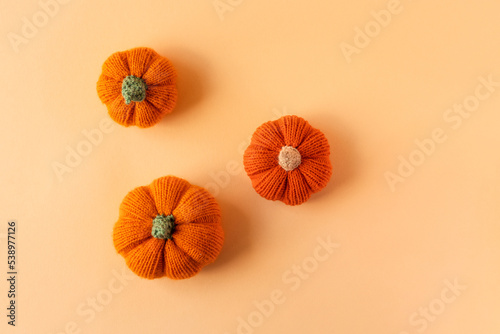 Knitted orange pumpkins on an orange background  autumn composition. Halloween concept.