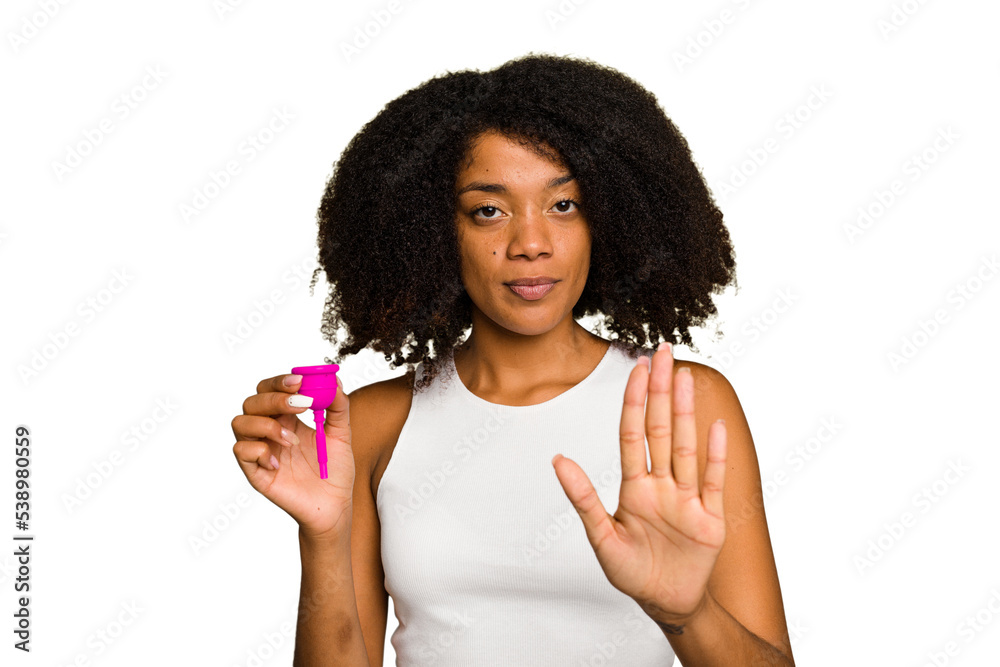 Young African American woman holding a menstrual cup isolated standing with outstretched hand showing stop sign, preventing you. Young African American woman holding a menstrual cup isolated standing with outstretched hand showing stop sign, preventing you.