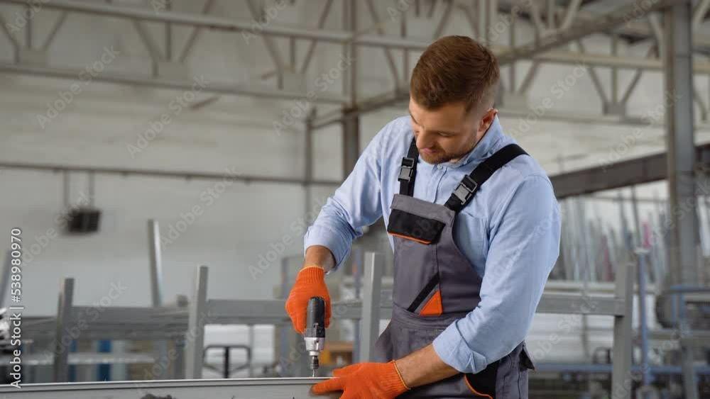 Manual worker assembling PVC doors and windows and working with screw gun. Factory for aluminum and PVC windows and doors production Manual worker assembling PVC doors and windows and working with screw gun. Factory for aluminum and PVC windows and doors production