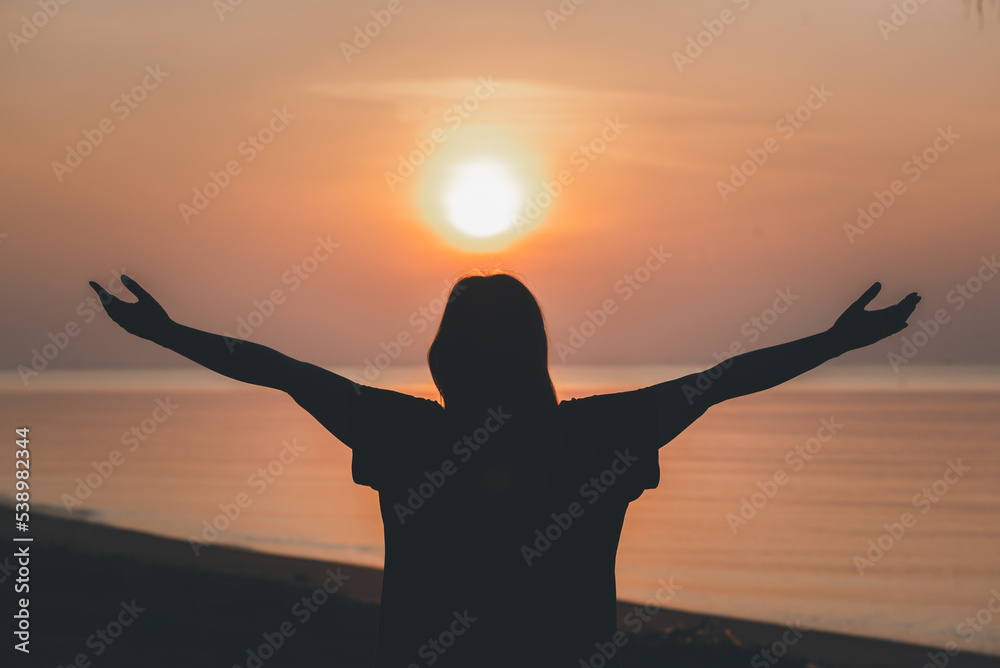 Silhouette of praying hands with God facing the sky at sunrise morning on the beach, Faith in religion and belief in God, Power of hope or love and devotion.