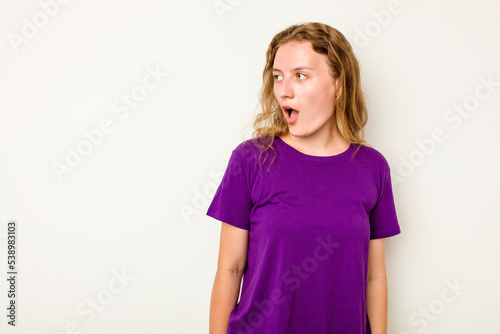 Young caucasian woman isolated on white background being shocked because of something she has seen.