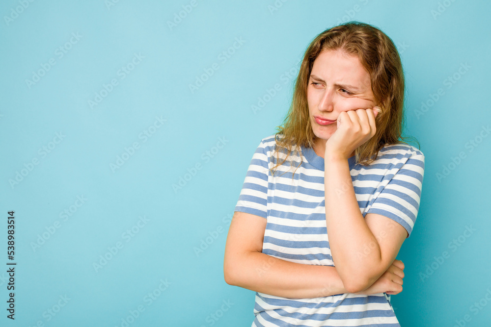 Young caucasian woman isolated on blue background who feels sad and pensive, looking at copy space.