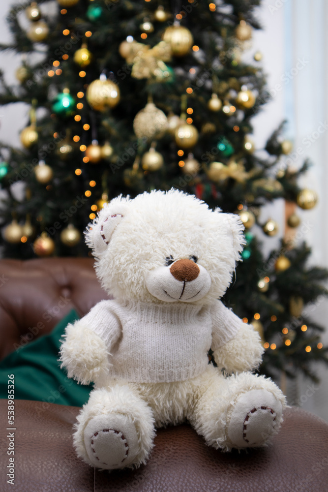 Isolate. White teddy bear on the background of the Christmas tree. Close-up. Copyspace Isolate. White teddy bear on the background of the Christmas tree. Close-up. Copyspace